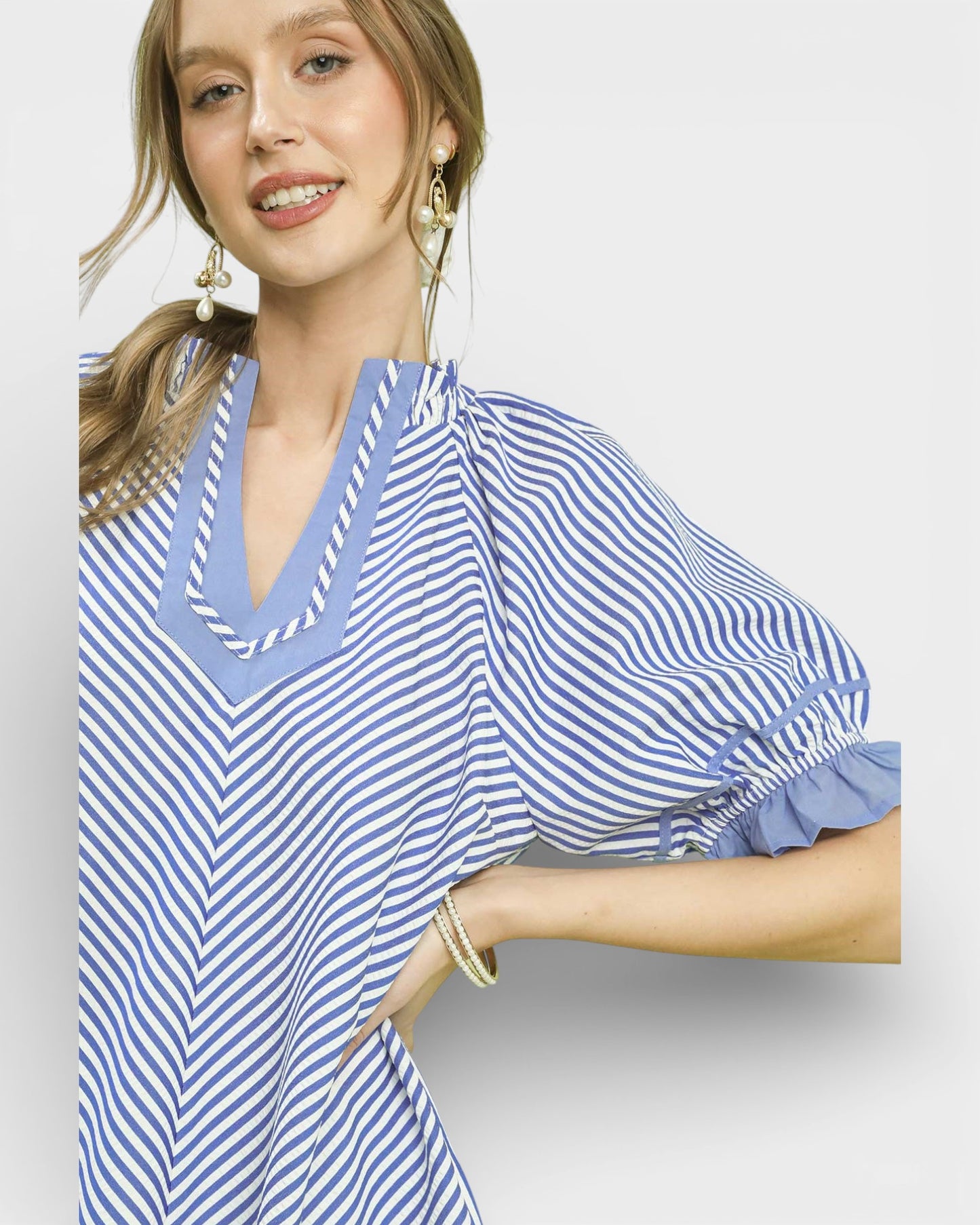 Woman wearing a blue and white striped dress on a plain background