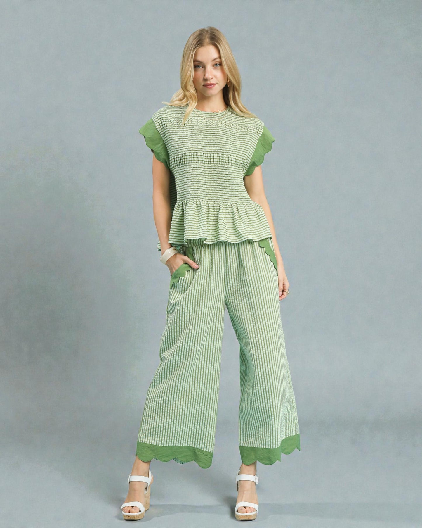 Woman wearing a green checkered outfit on a gray background