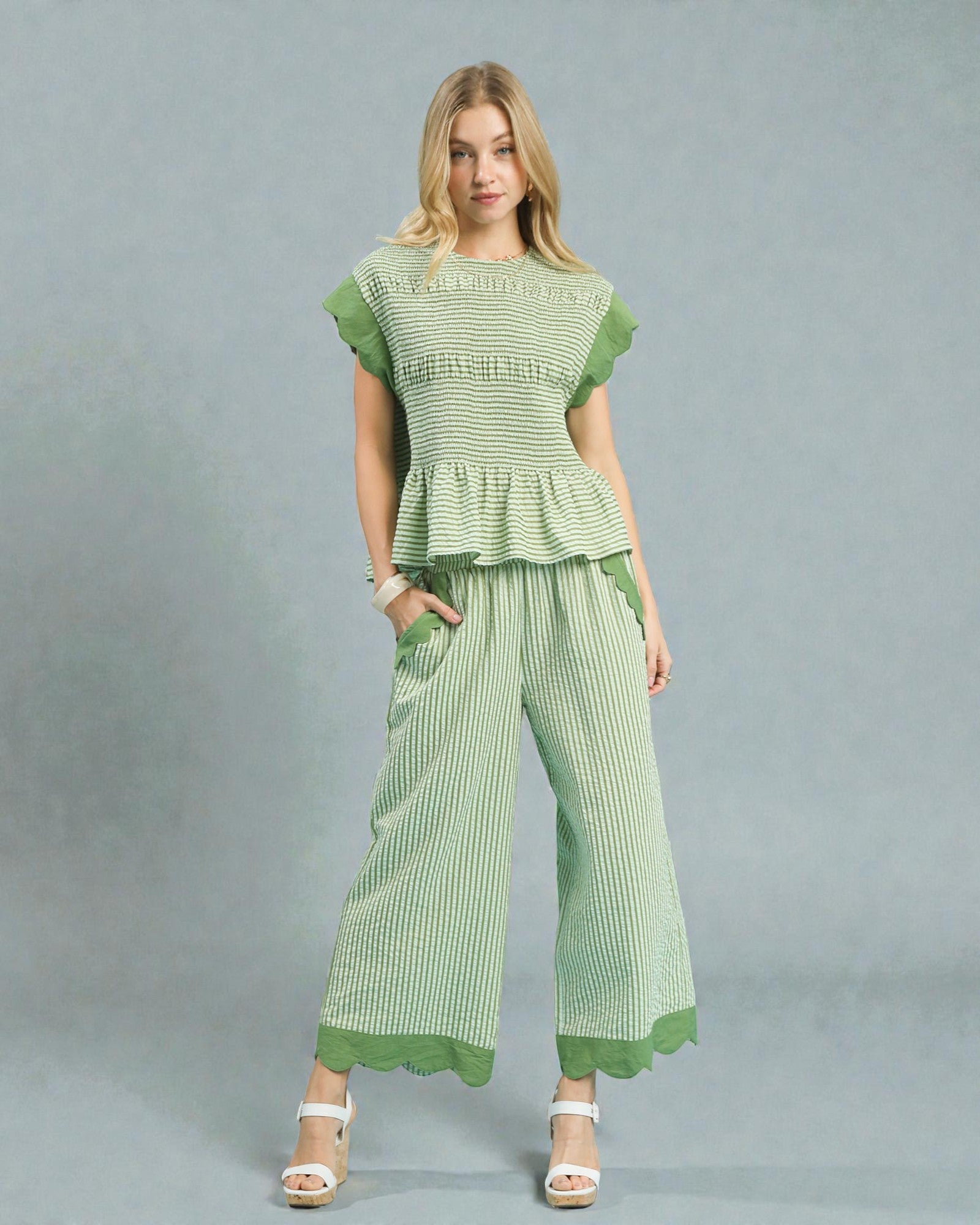 Woman wearing a green checkered outfit on a gray background