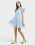 Woman wearing a light blue dress with ruffled sleeves on a white background