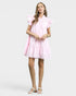 Woman wearing a pink dress with ruffled sleeves on a white background
