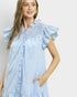Woman wearing a blue and white striped dress with ruffled sleeves against a plain background
