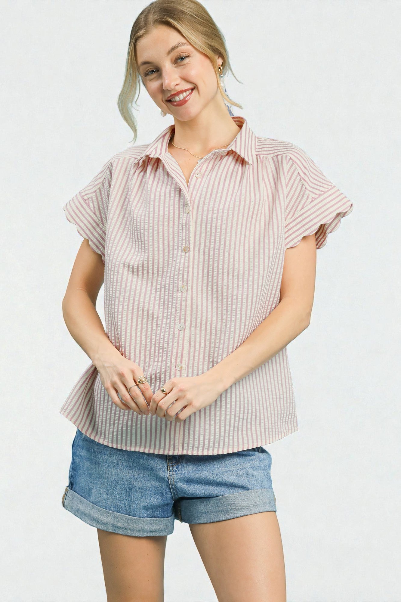 Woman wearing a striped shirt and denim shorts on a white background