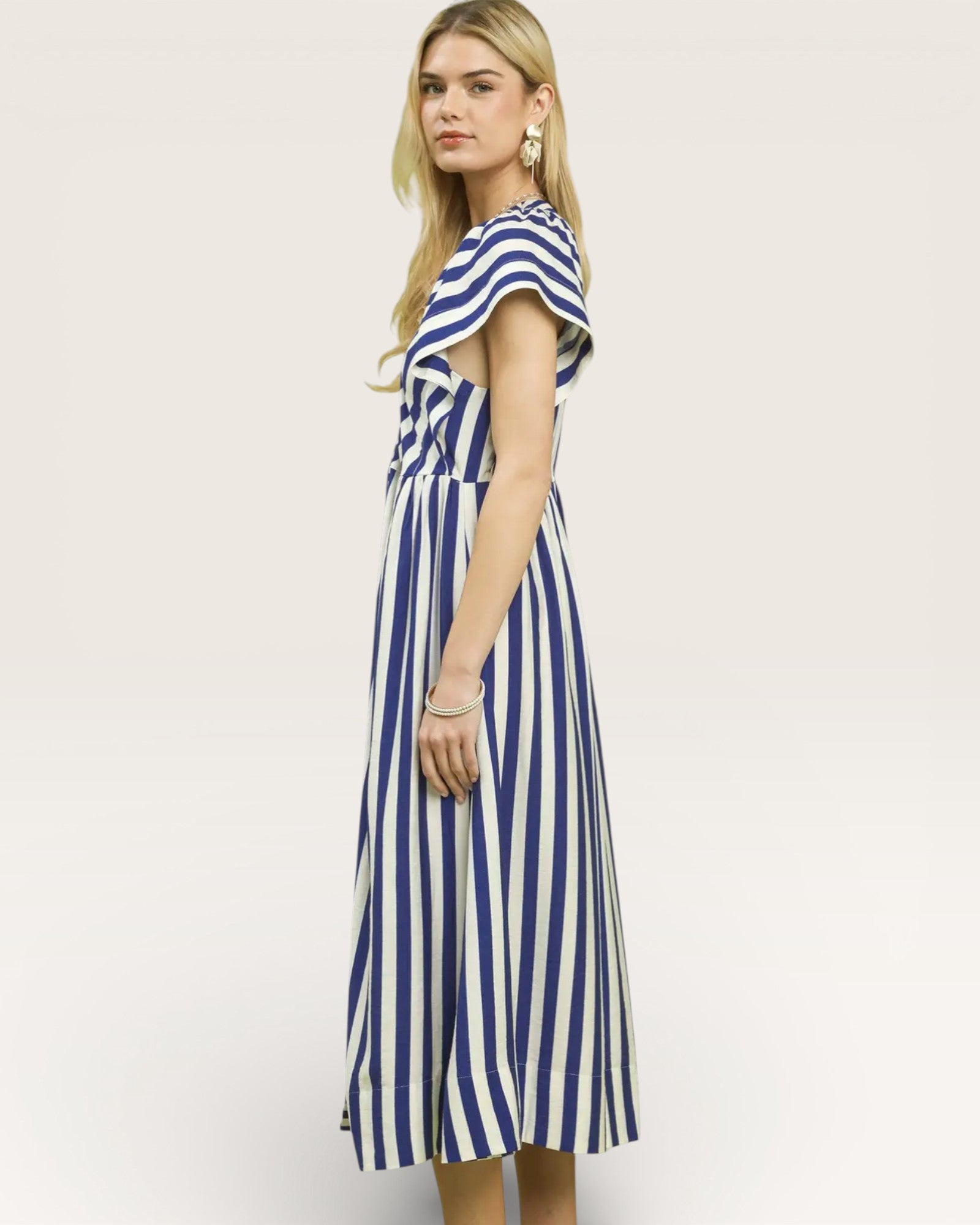 Woman wearing a blue and white striped dress on a plain background