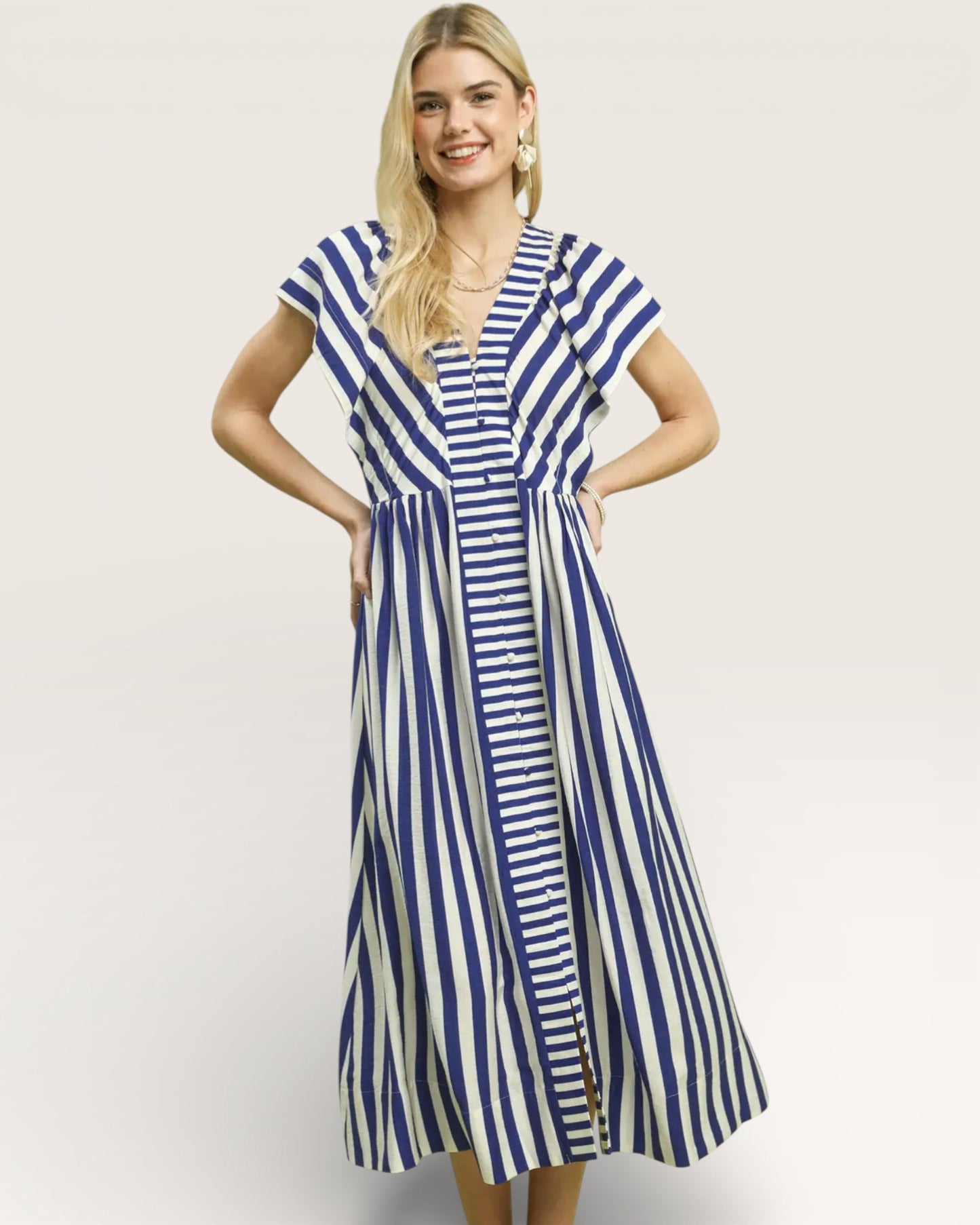 Woman wearing a blue and white striped dress on a plain background