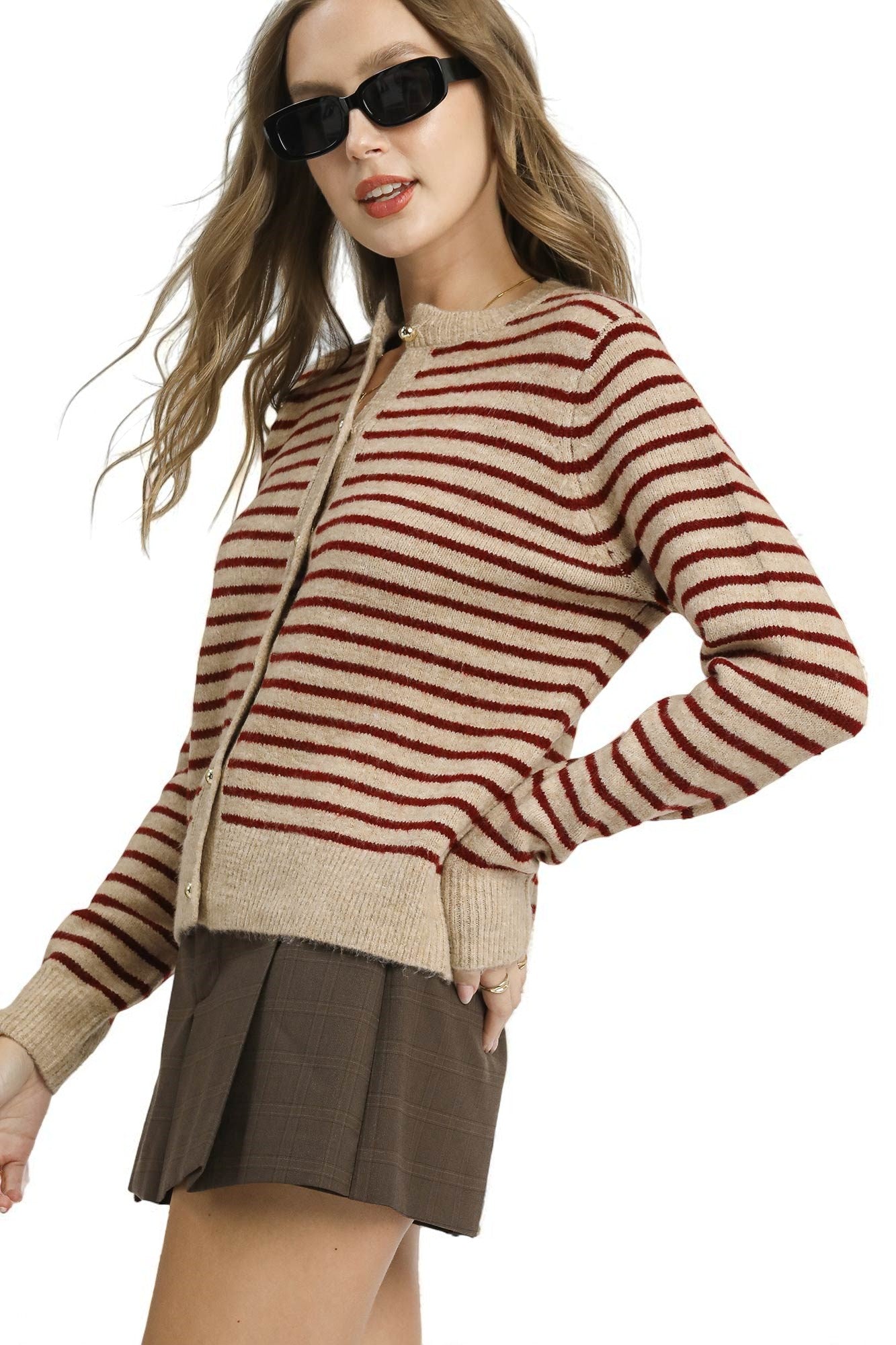 Woman wearing a striped sweater and skirt on a white background