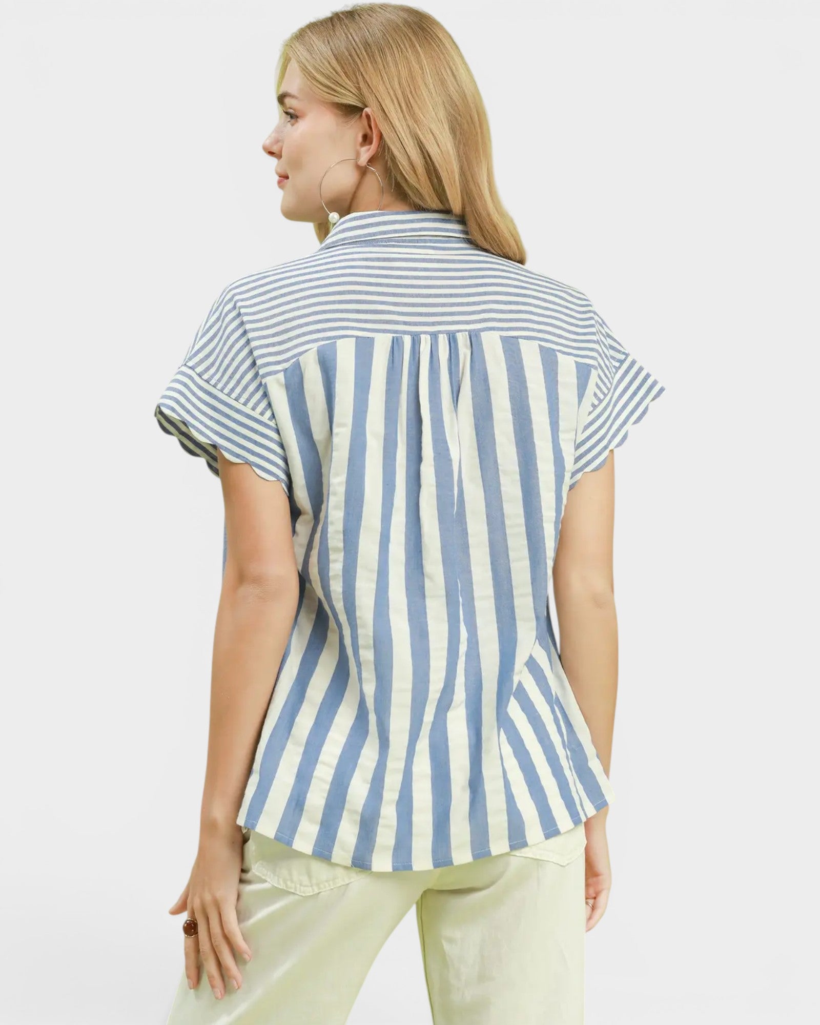 Woman wearing a blue and white striped shirt on a light gray background