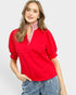 Woman wearing a red blouse with a white background