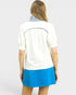 Woman wearing a white blouse with a blue skirt on a plain background