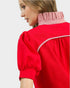 Red blouse with striped collar on a white background