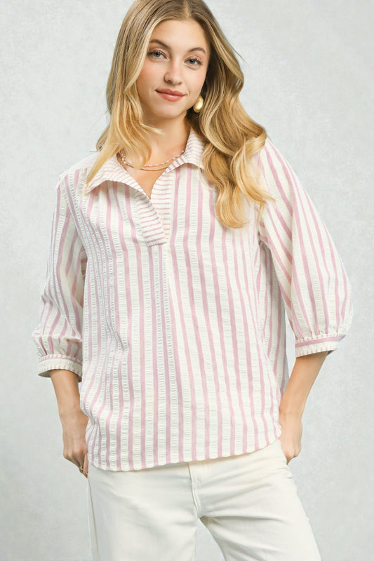 Woman wearing a pink and white striped shirt against a plain background