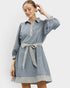Woman wearing a blue dress with striped details on a white background