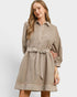 A woman modeling a taupe-brown long-sleeve mini dress with a striped collar, button placket, cuffs, hem, and matching tie belt, set against a plain light gray studio background.