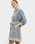 Woman wearing a blue robe with striped trim on a white background