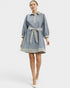 Woman wearing a blue dress with a belt on a white background