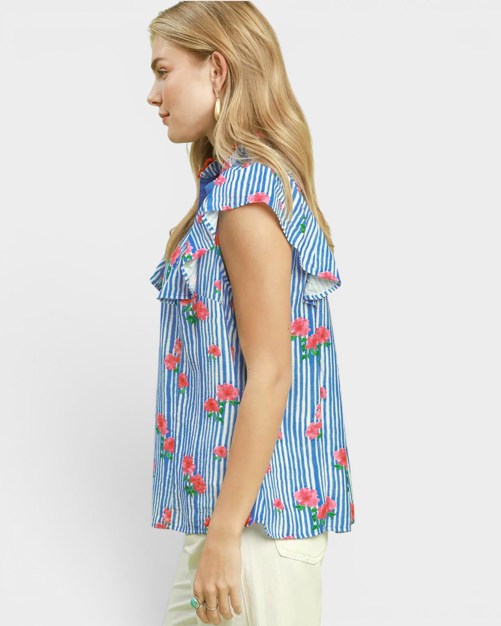 Woman wearing a blue striped shirt with floral patterns on a white background