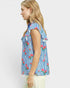 Woman wearing a blue striped shirt with floral patterns on a white background
