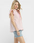 Woman wearing a pink and white striped sleeveless blouse with denim shorts on a white background