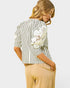 Woman wearing a striped shirt with lace detailing on a light gray background