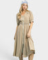 Woman wearing a beige striped dress with a belt on a white background