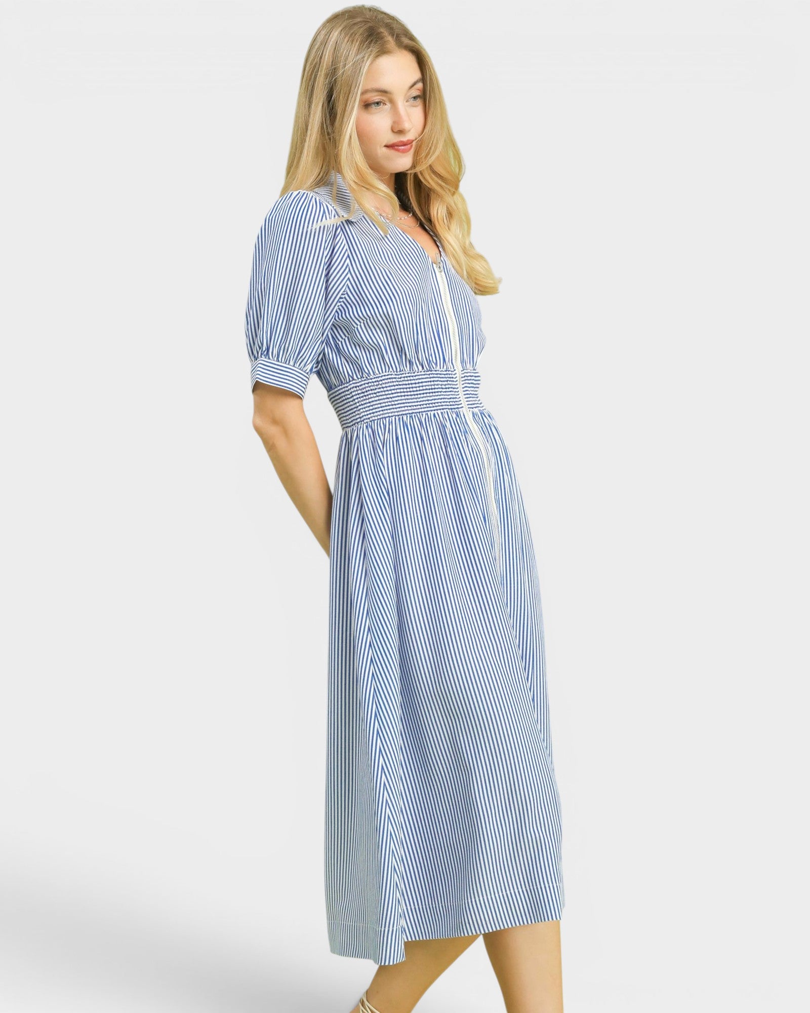 Woman wearing a blue and white striped dress on a white background