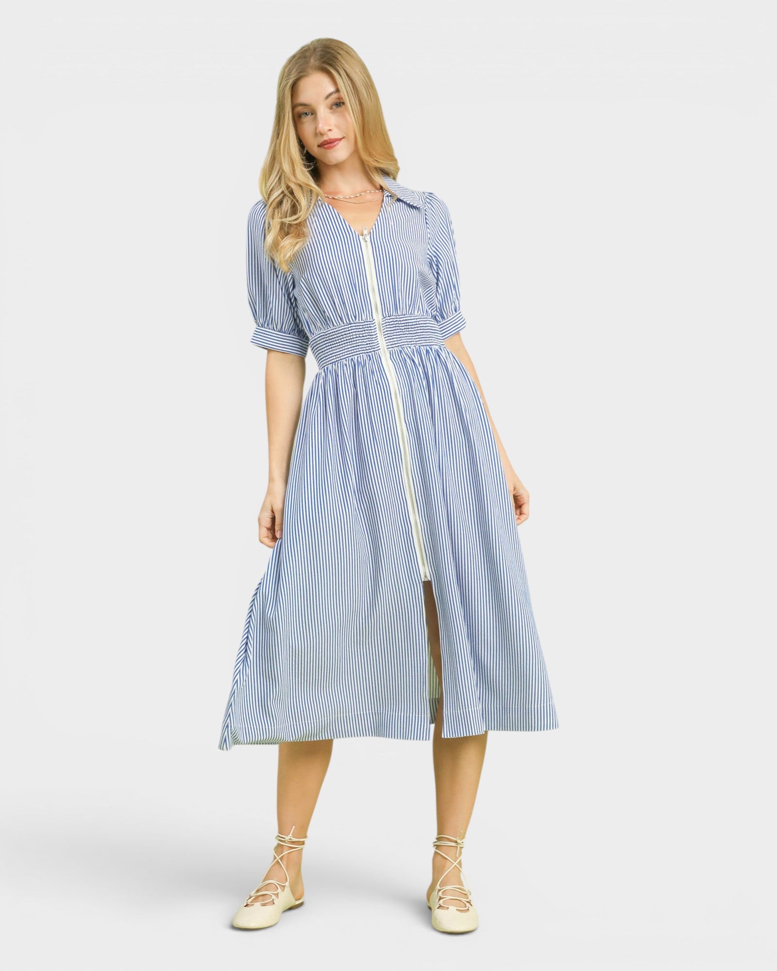 Woman wearing a blue and white striped dress on a white background