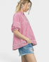 Woman wearing a red and white striped shirt and denim shorts on a white background