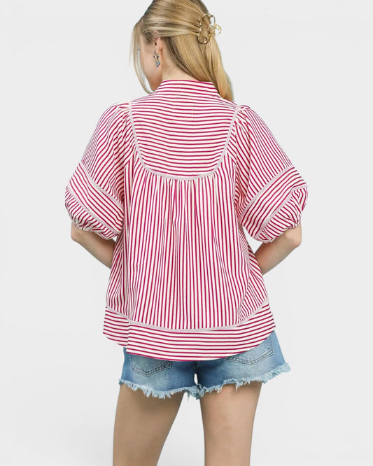 Person wearing a red and white striped shirt with denim shorts on a white background