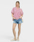 Woman wearing a red and white striped blouse and denim shorts on a white background