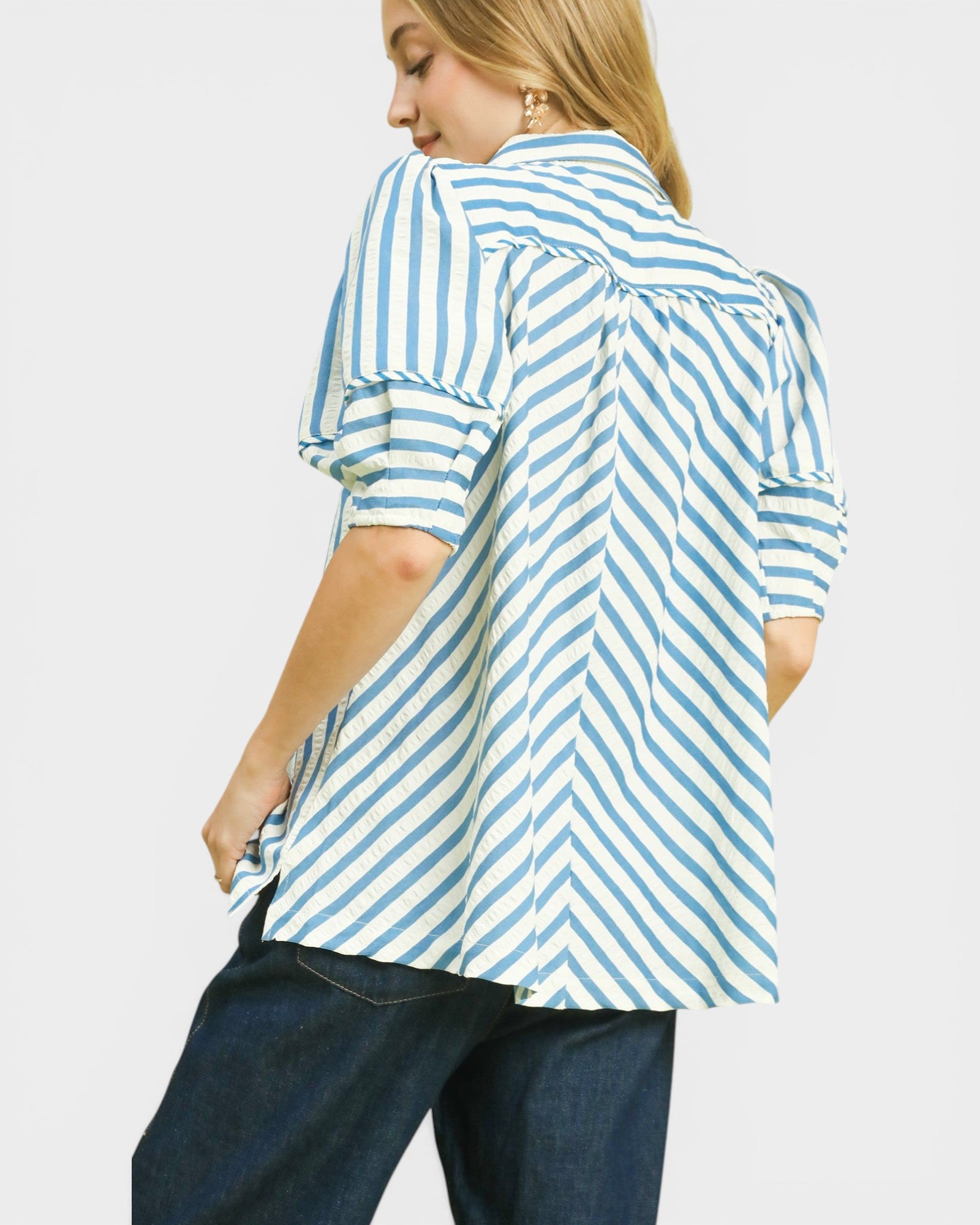 Person wearing a blue and white striped shirt on a plain background