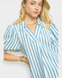 Woman wearing a blue and white striped shirt against a plain background