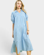 Woman wearing a blue and white striped dress on a white background