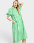 Woman wearing a green and white striped dress on a white background