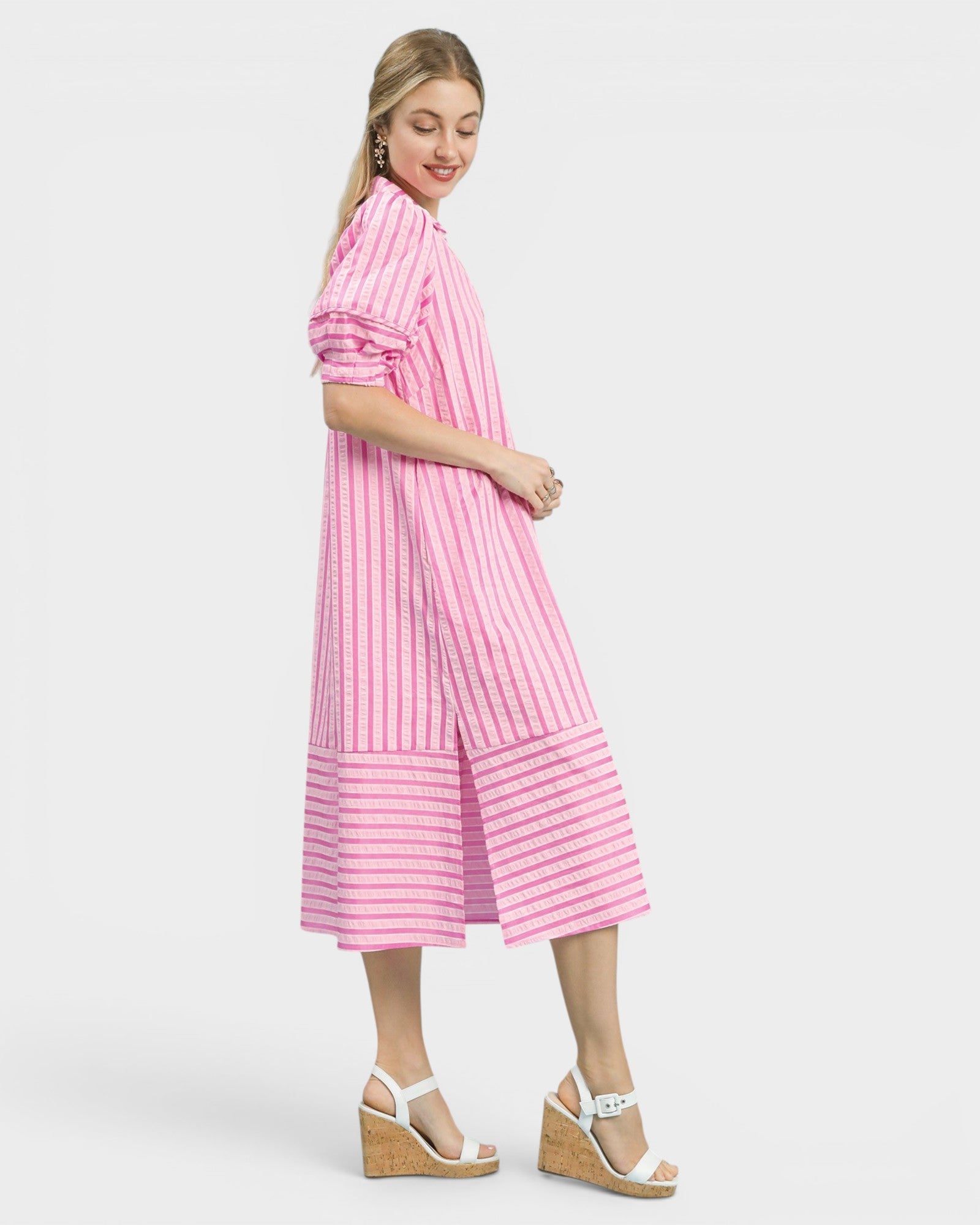 Woman wearing a pink and white striped dress on a white background