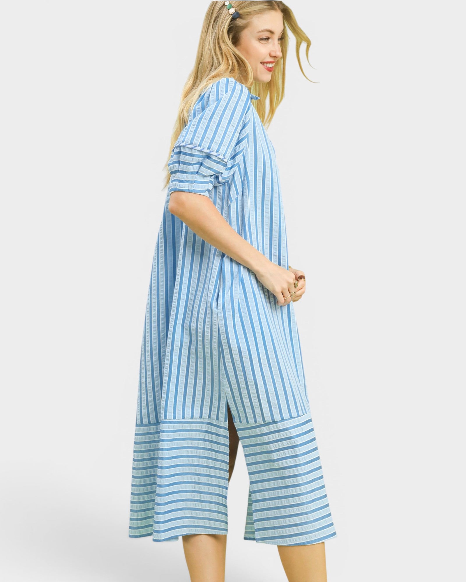 Woman wearing a blue and white striped dress on a plain background
