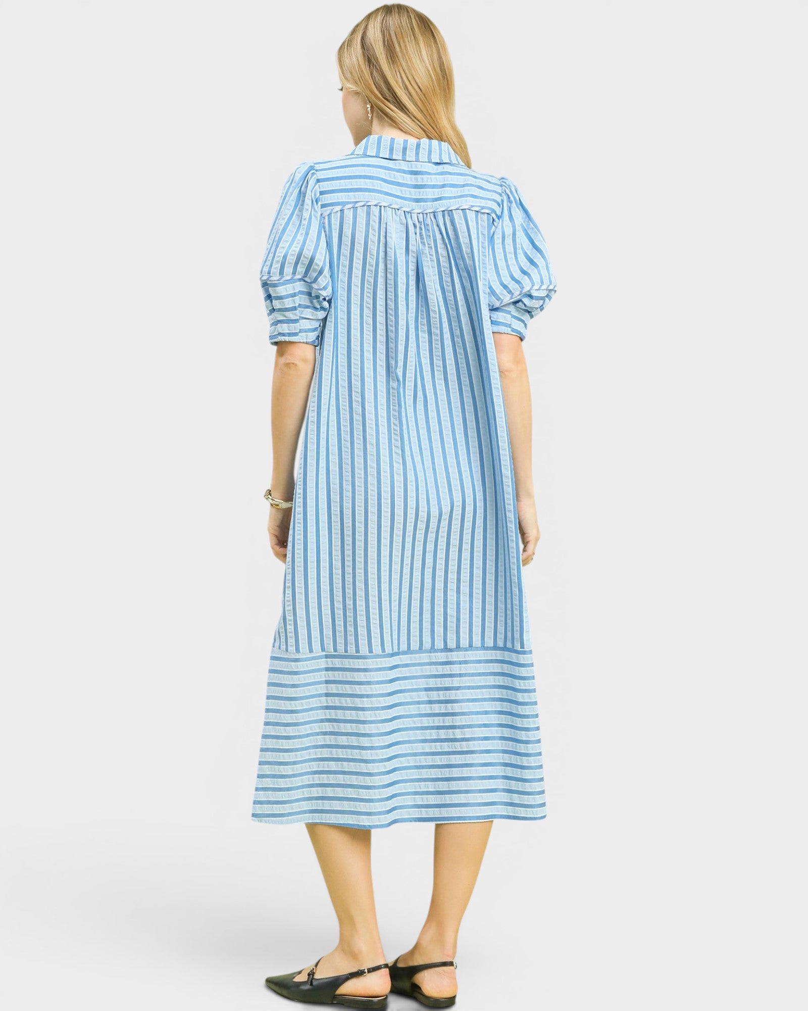 Woman wearing a blue and white striped dress on a white background