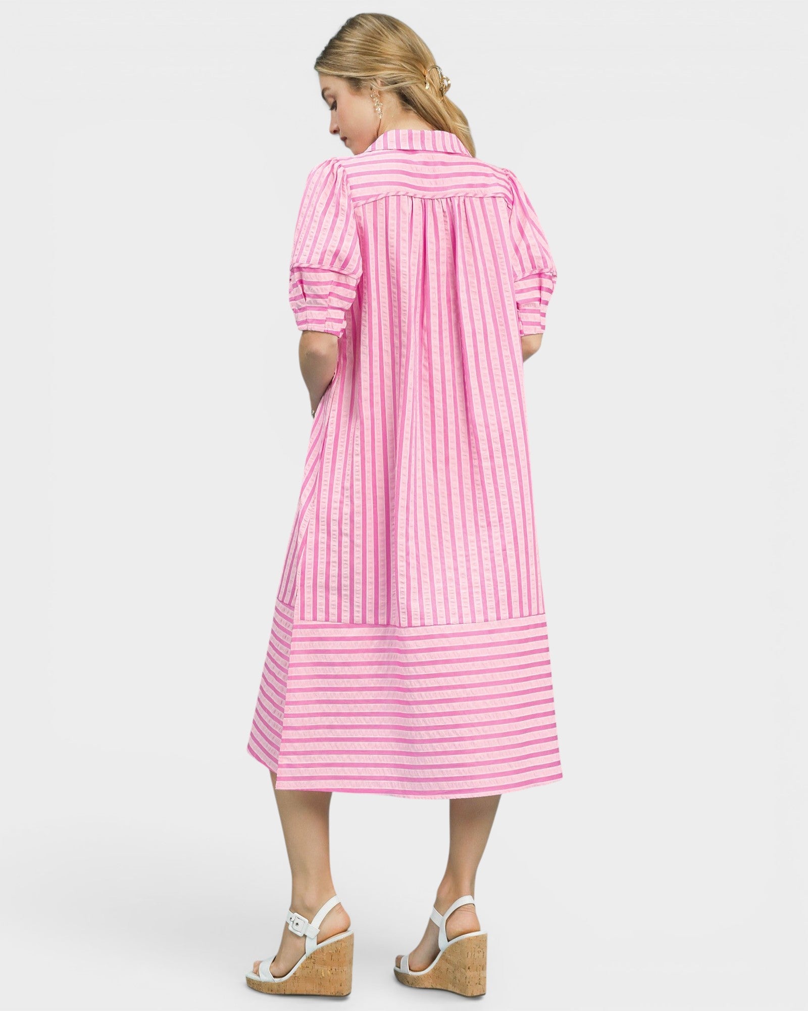 Woman wearing a pink and white striped dress on a white background