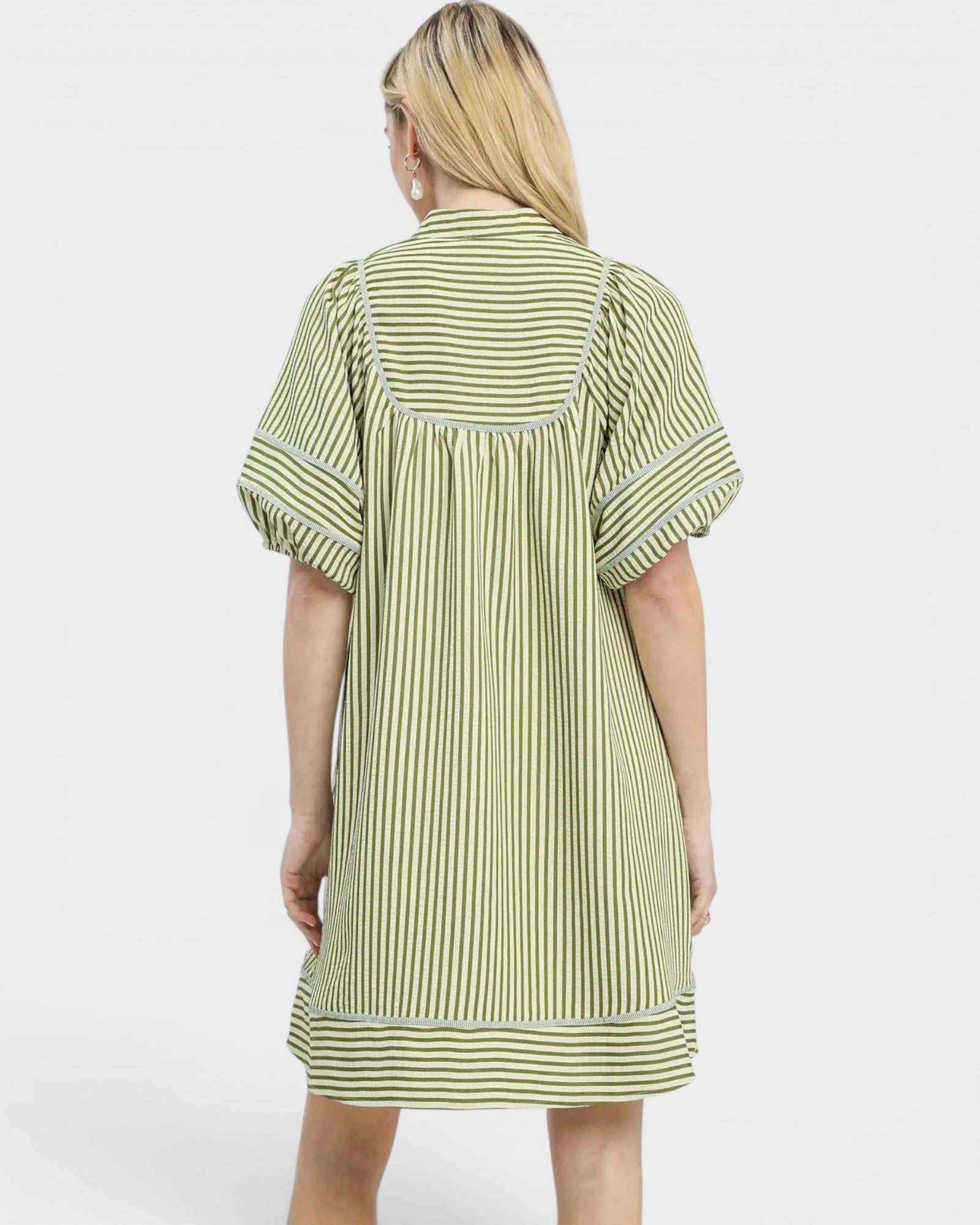Woman wearing a green and white striped dress on a white background