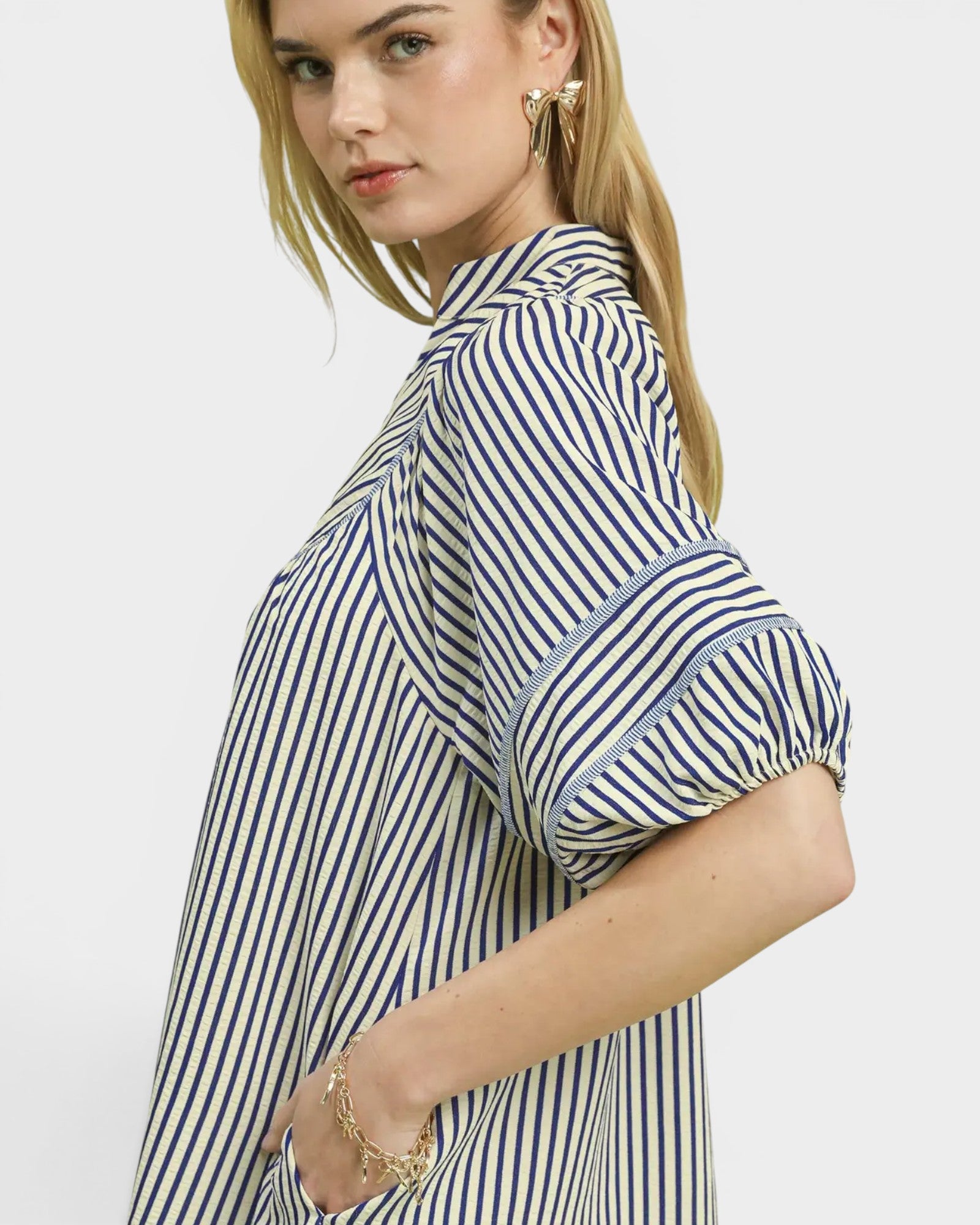Woman wearing a blue and white striped shirt on a plain background