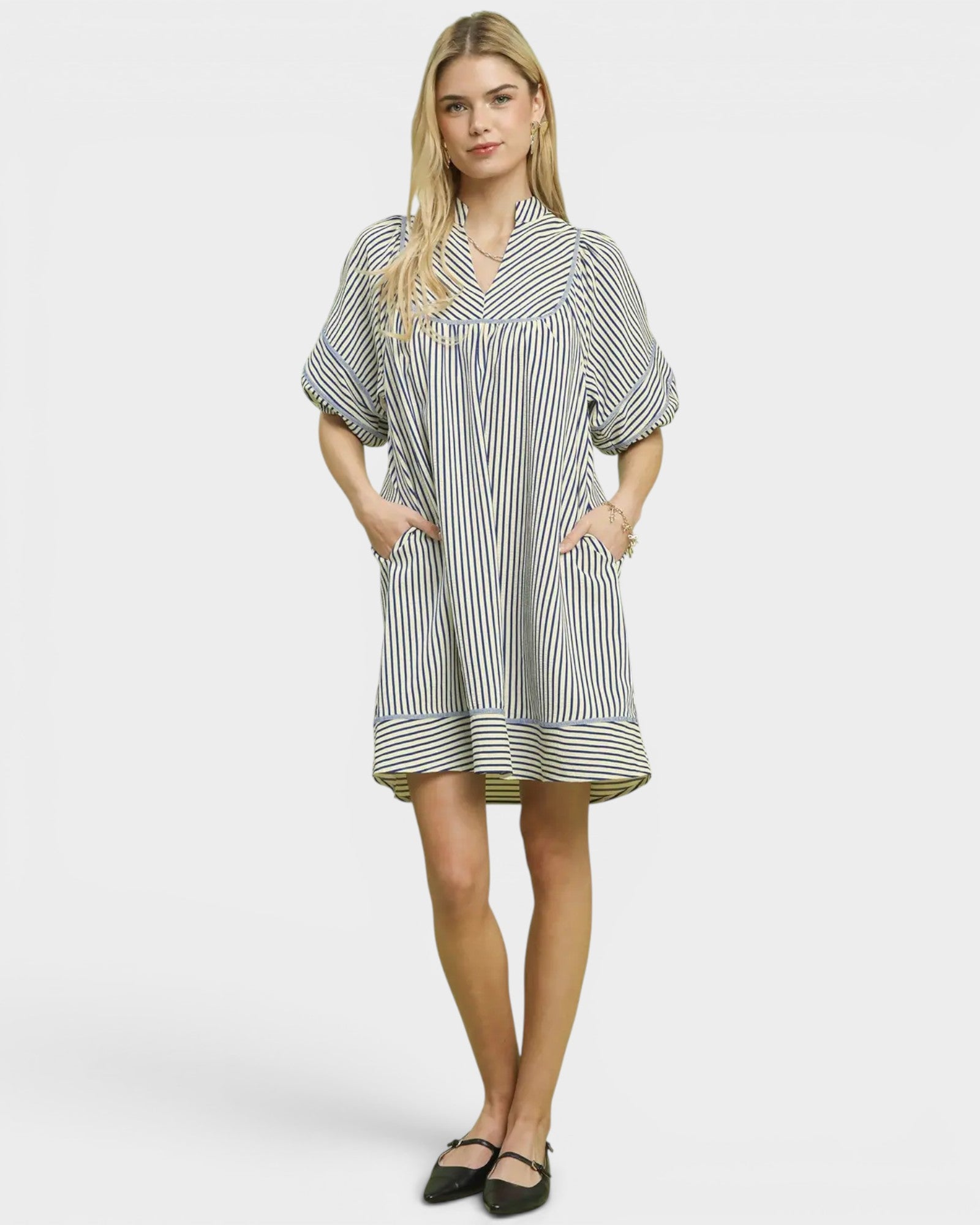 Woman wearing a striped dress on a plain background