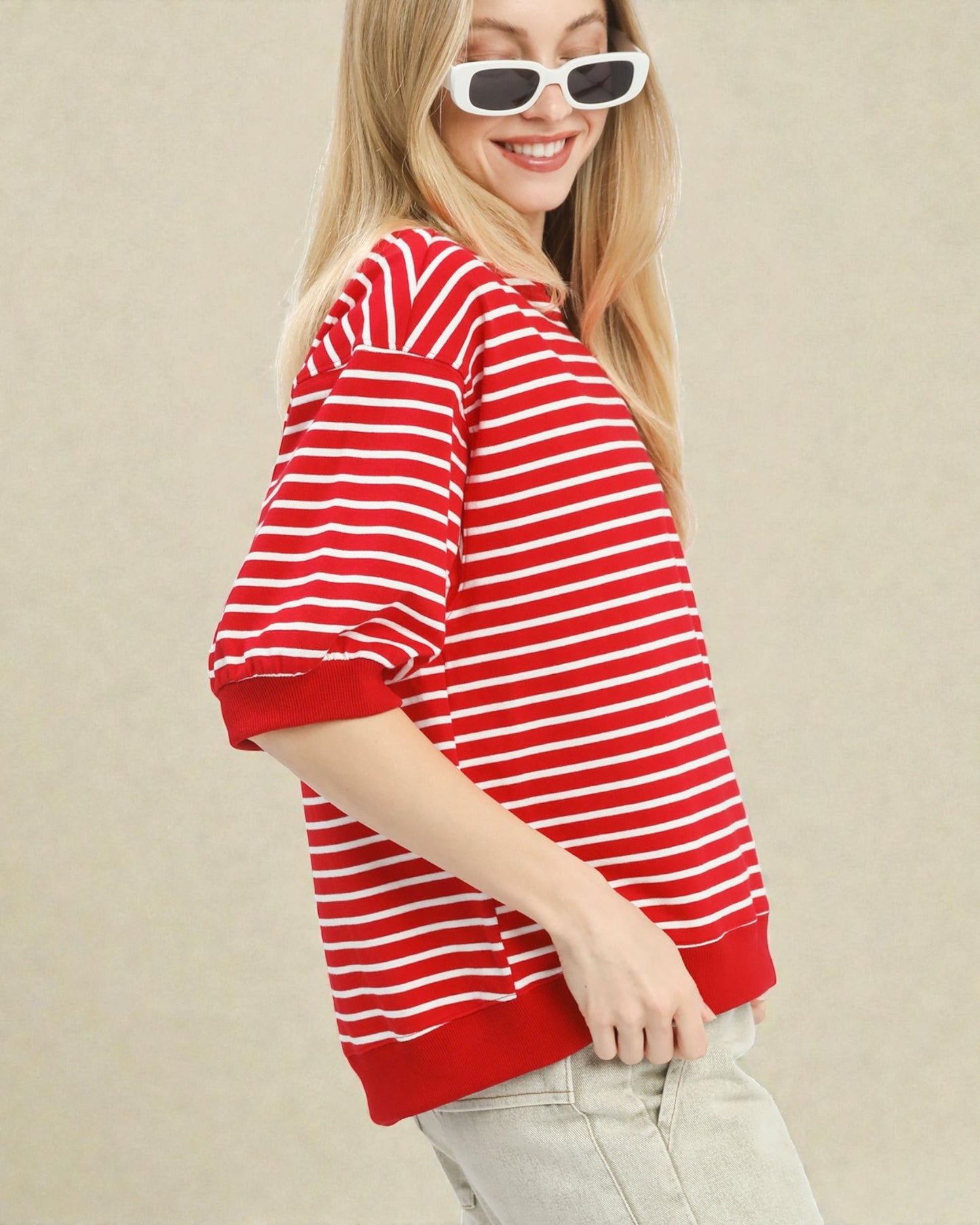 Woman wearing a red and white striped shirt against a beige background