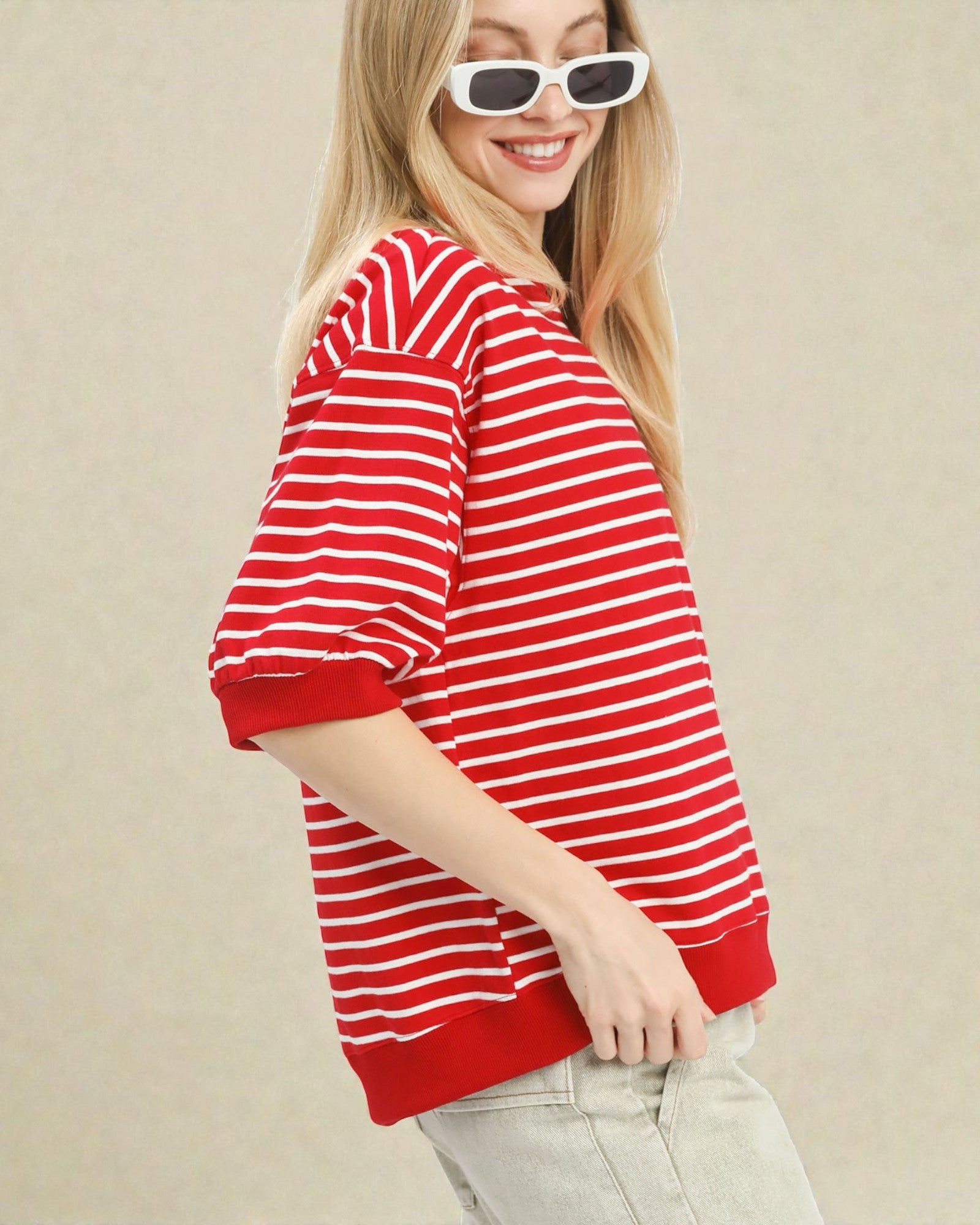 Woman wearing a red and white striped shirt against a beige background