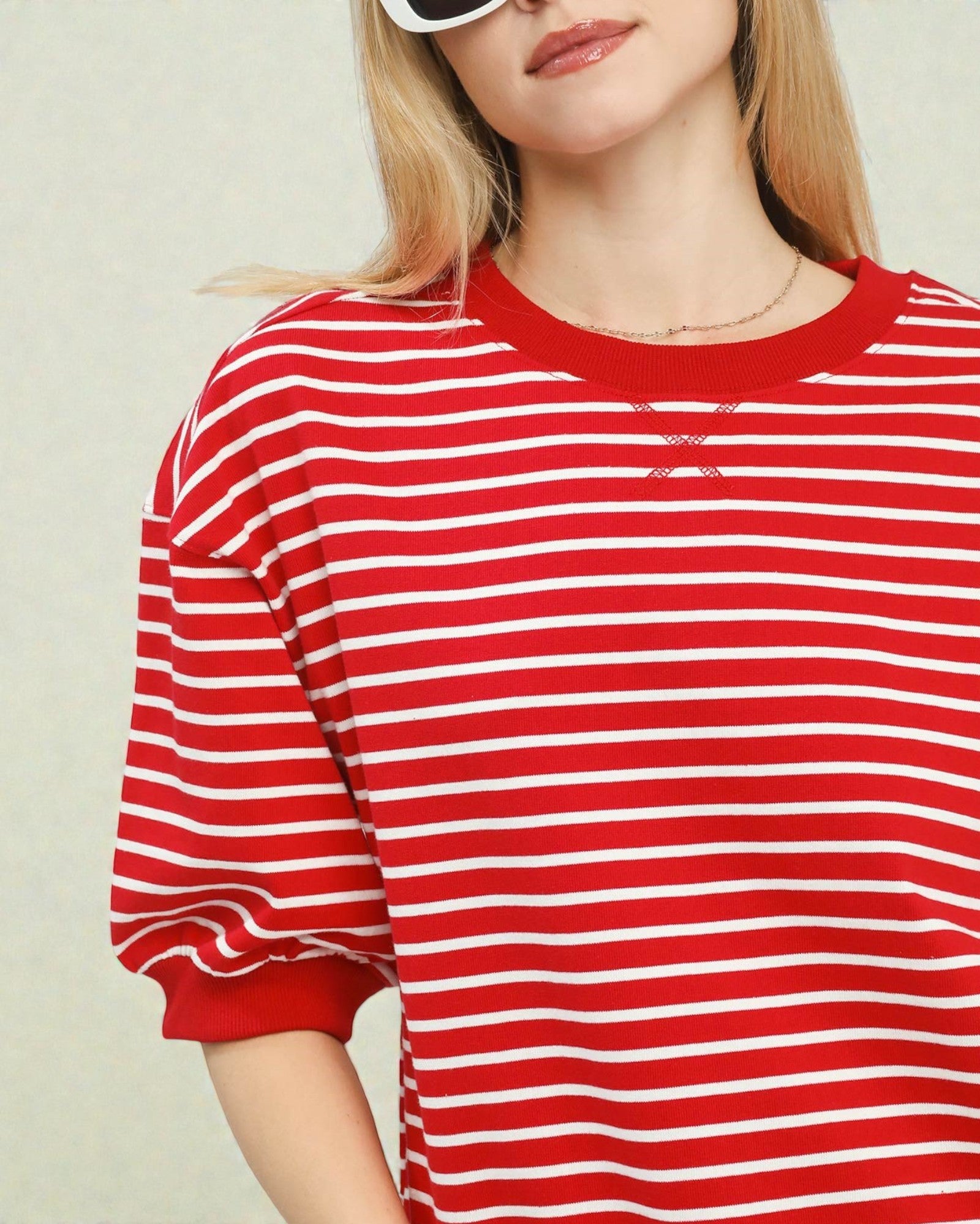 Person wearing a red and white striped shirt against a plain background