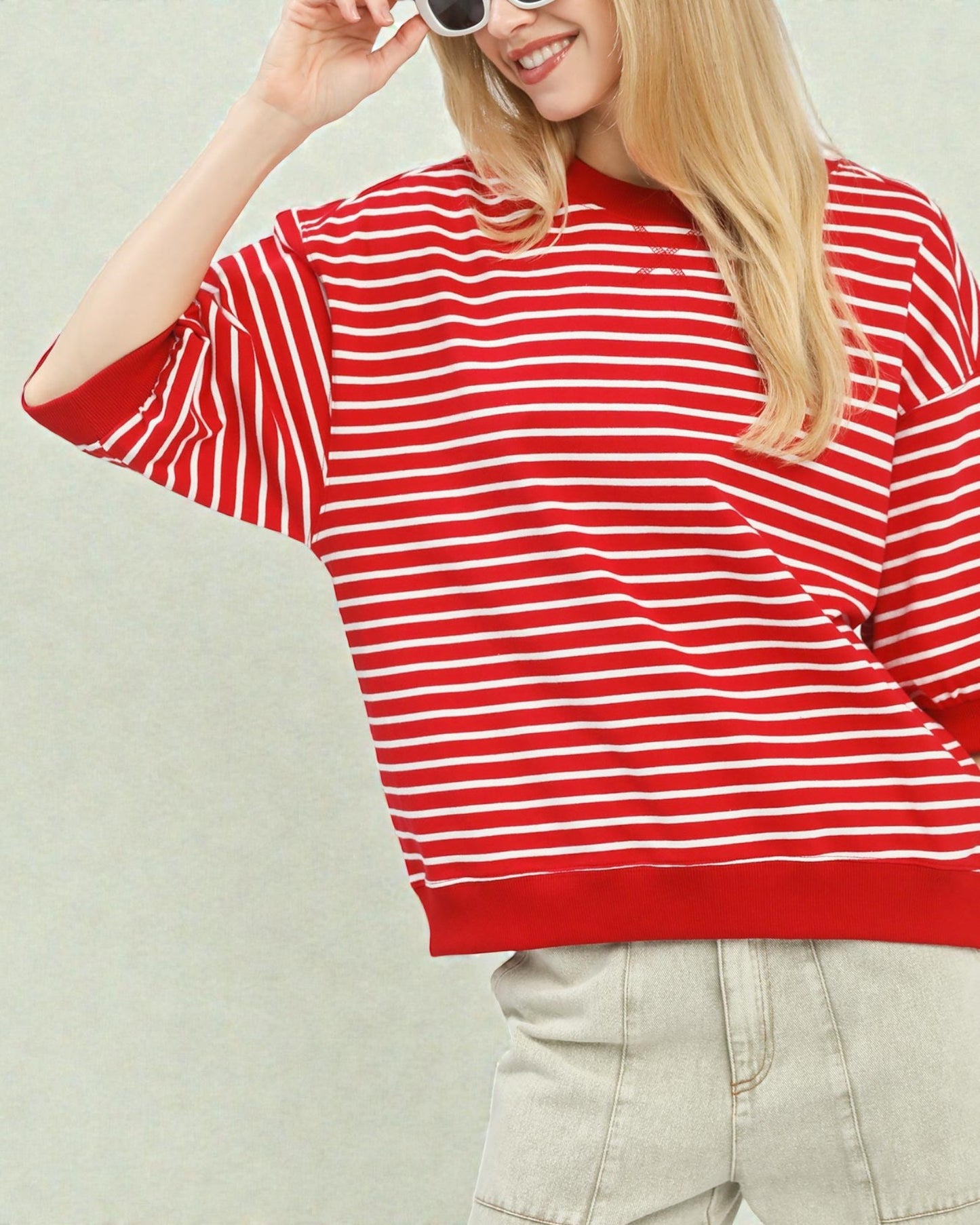Person wearing a red and white striped shirt against a plain background