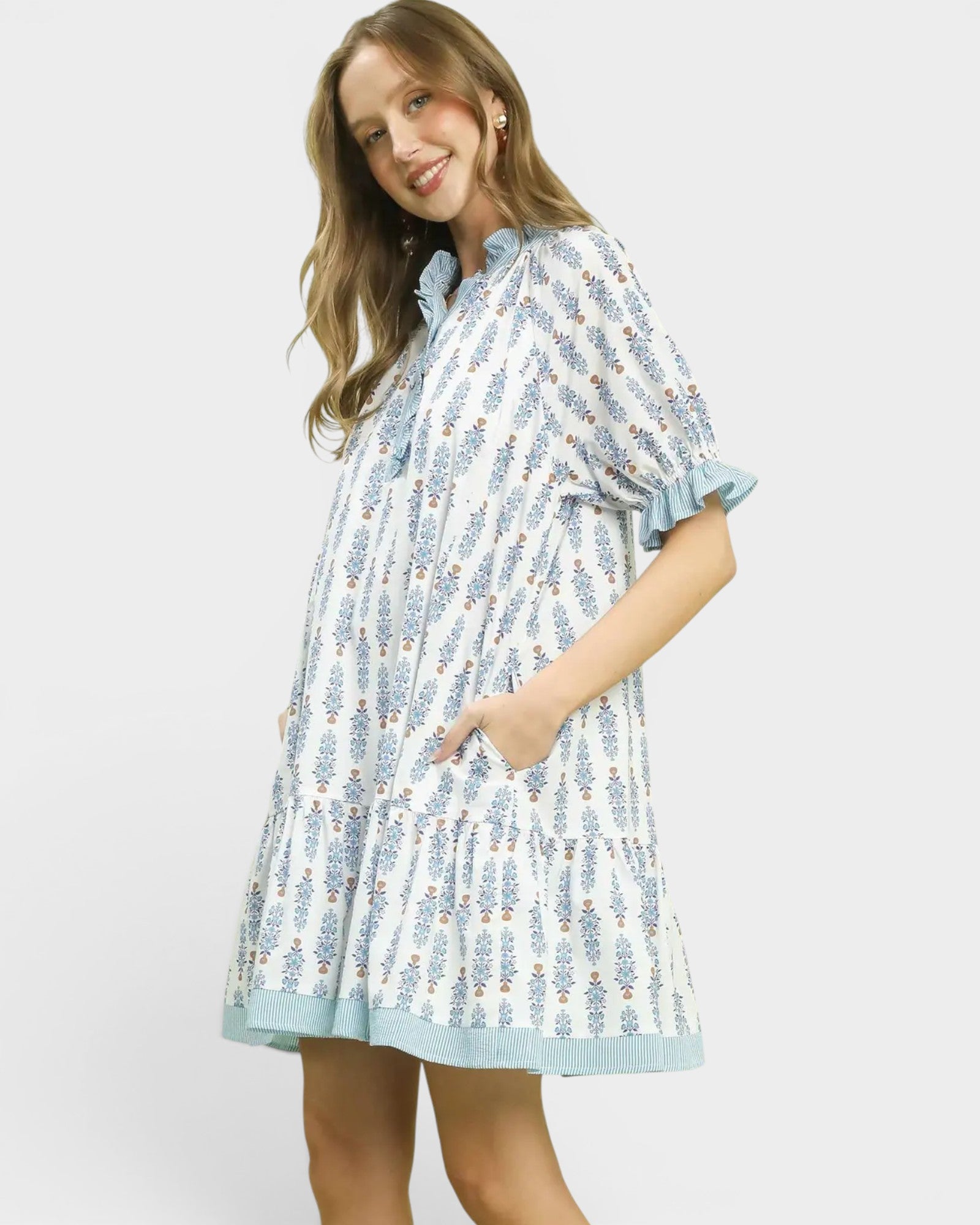 Woman wearing a light blue patterned dress on a white background
