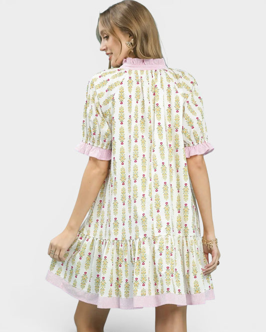 Woman wearing a floral dress with pink trim on a white background