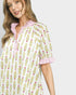 Woman wearing a floral nightshirt with pink accents on a white background