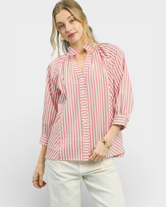 Woman wearing a red and white striped shirt with a bow detail on a white background