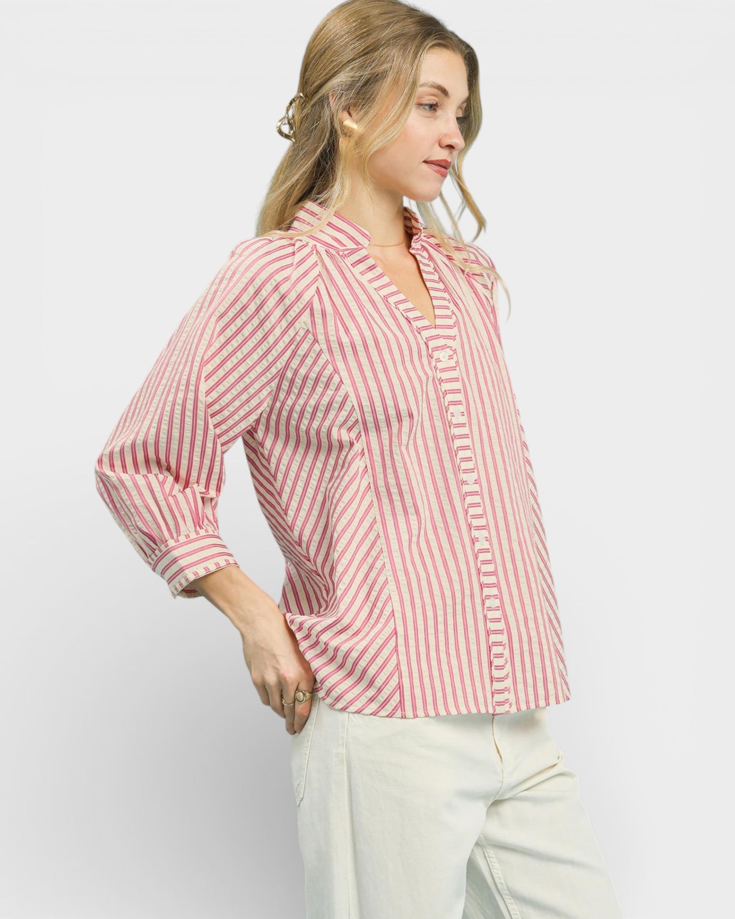 Woman wearing a red and white striped shirt against a plain background