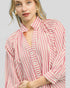 Woman wearing a pink and white striped blouse against a plain background